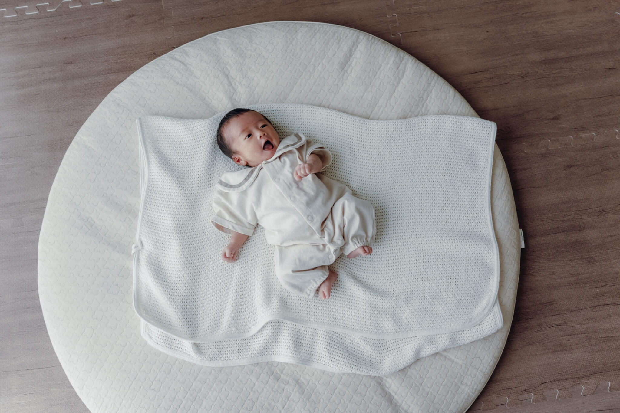 流山での自宅ニューボーンフォト|丸いラグの上でくつろぐ赤ちゃんの全身写真