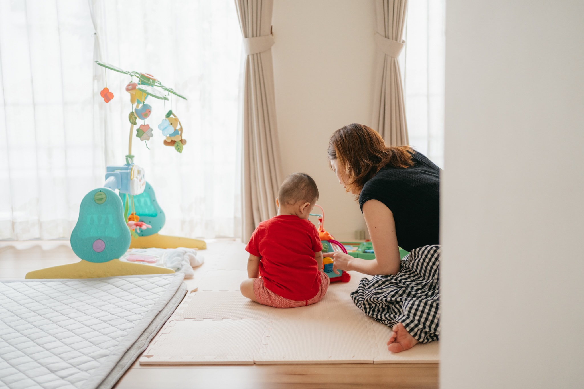 柏・流山エリア｜自宅で過ごす母と子の時間を自然な光の中で撮影した後ろ姿の写真
