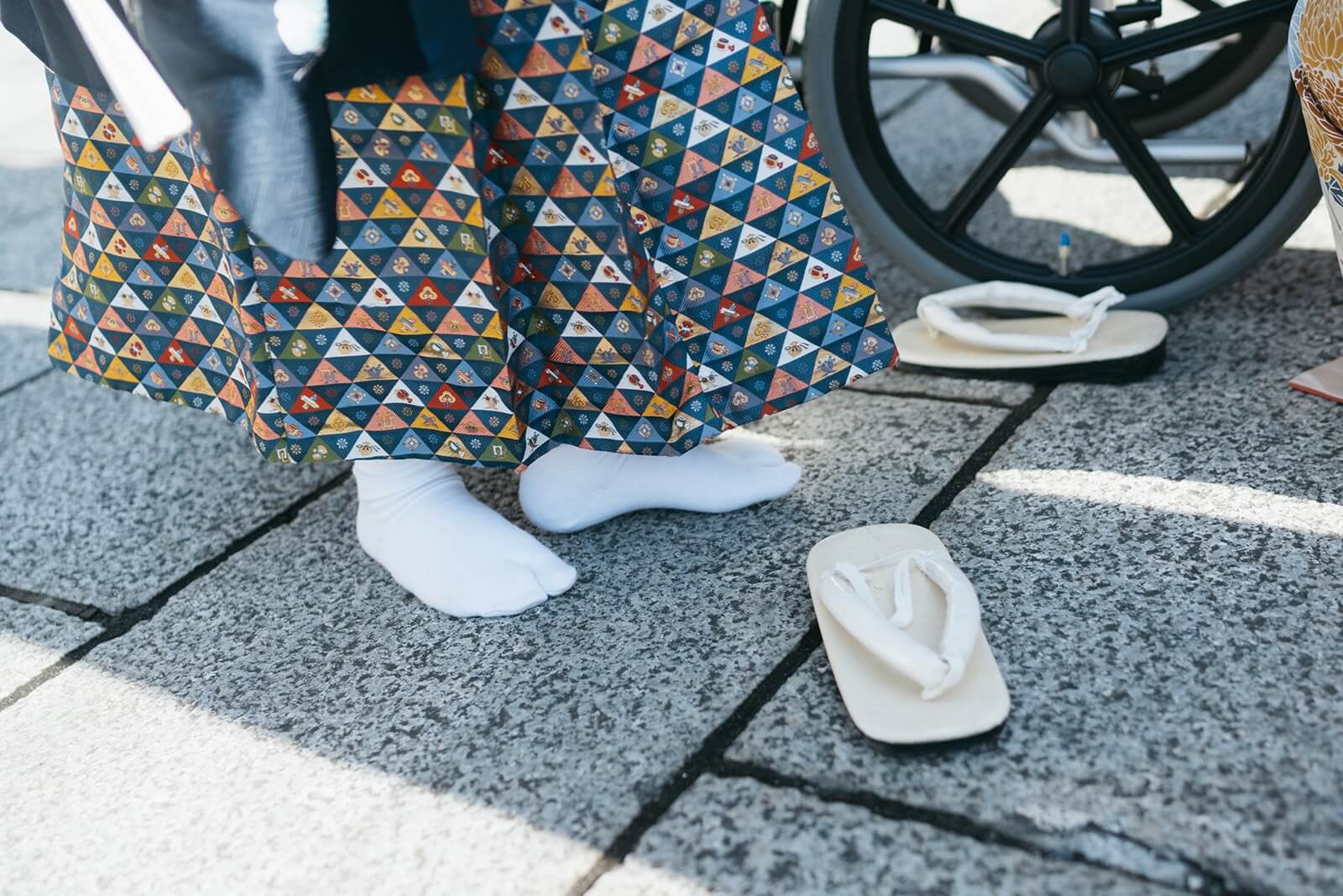 七五三で草履を脱ぎ、足袋のまま立つ子どもと境内に置かれた草履