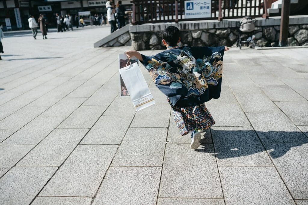 七五三のご祈祷を終えて、千歳飴を持って元気に走る男の子
