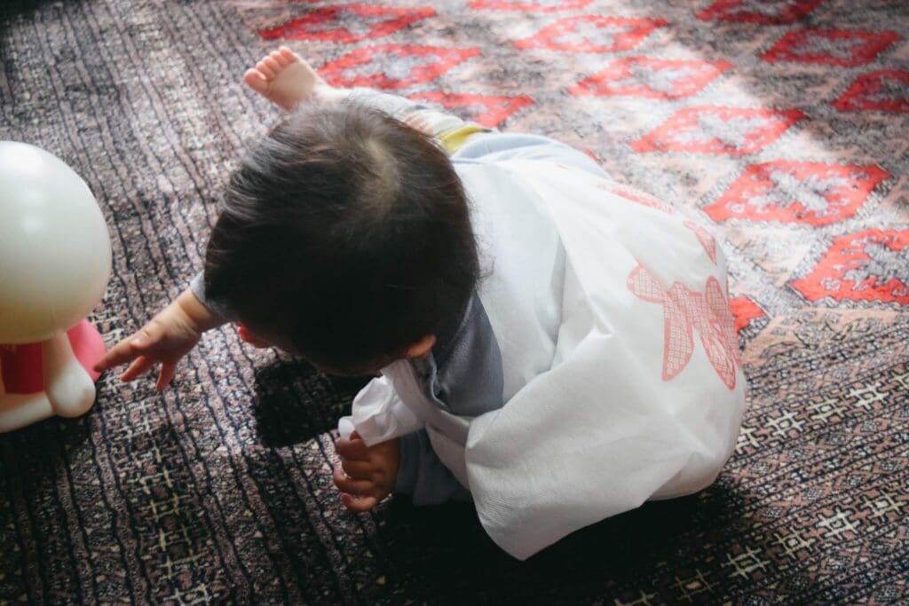 一升餅を背負って転がってしまう1歳誕生日の自宅写真