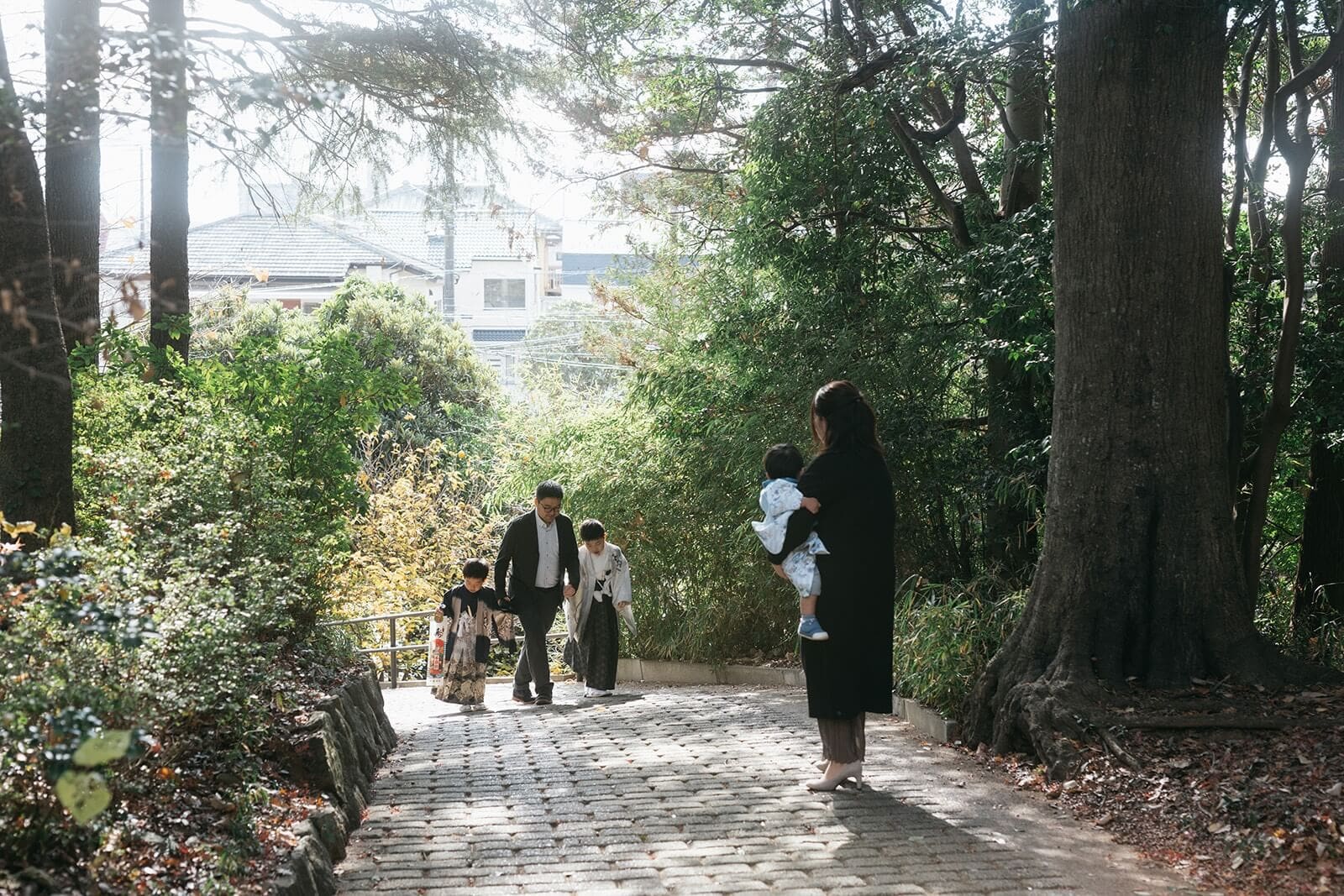 七五三で神社の境内を歩く着物姿の子どもと家族