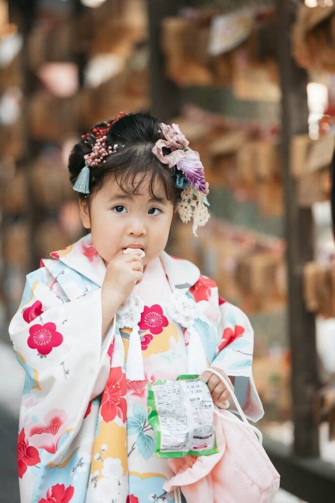 神社での祈祷後、おやつを食べる3歳女の子