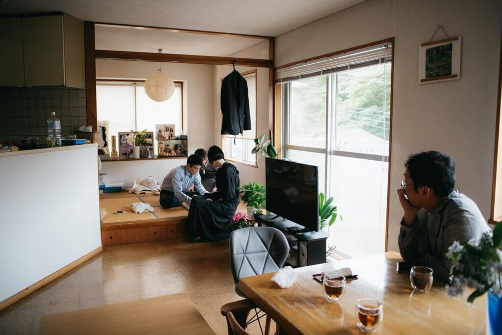 赤ちゃんのお世話の様子を見つめる親族